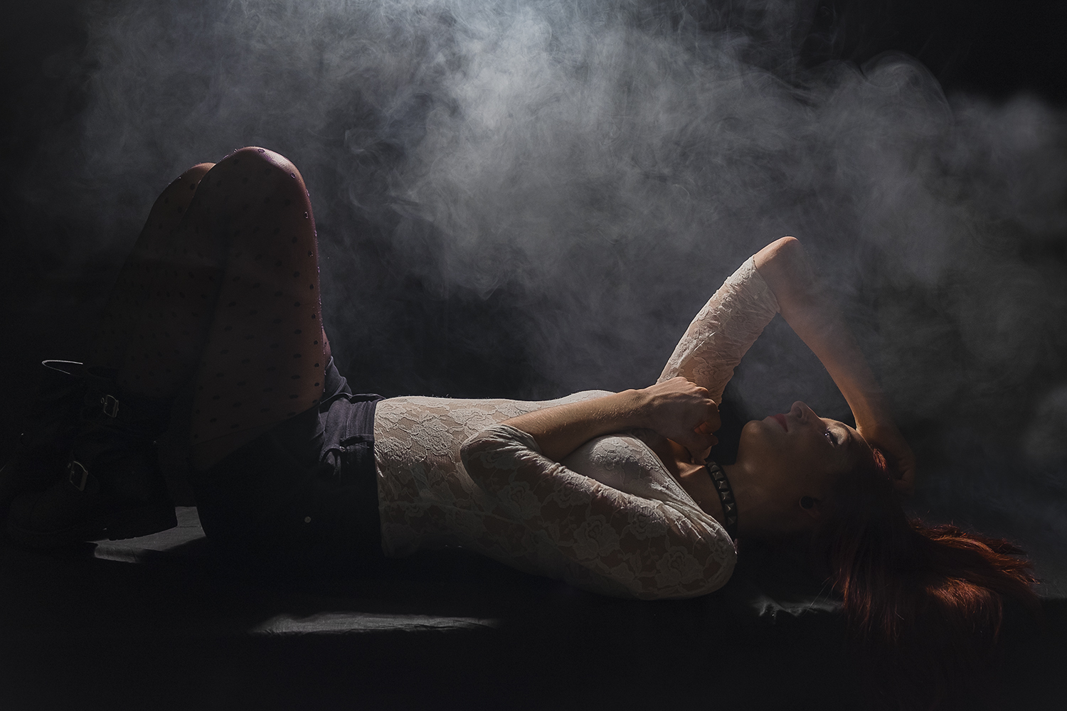 Sara Ginger modella rossa trasparenze effetto Rembrandt sfondo nero sdraiata fumo